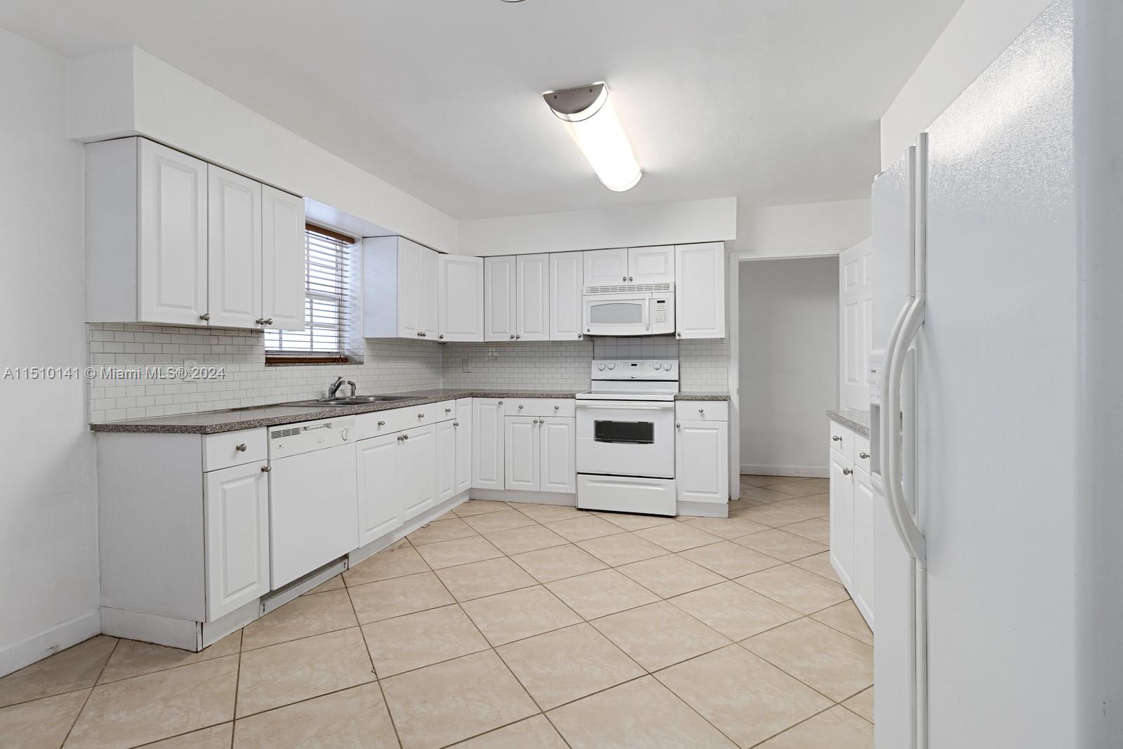 2037 Southwest 22nd Terrace Miami, FL 33145 - Photo 12 of 19 a kitchen with stainless steel appliances a refrigerator sink and cabinets