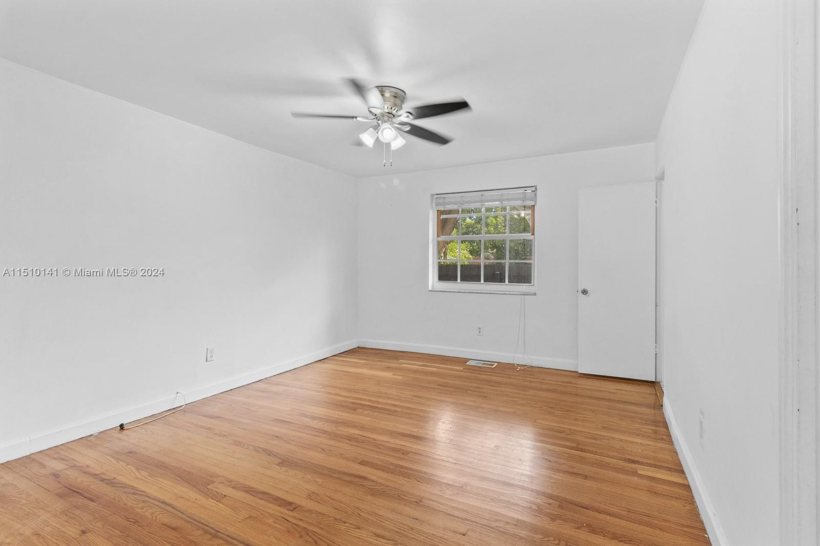 2037 Southwest 22nd Terrace Miami, FL 33145 - Photo 14 of 19 an empty room with wooden floor fan and windows