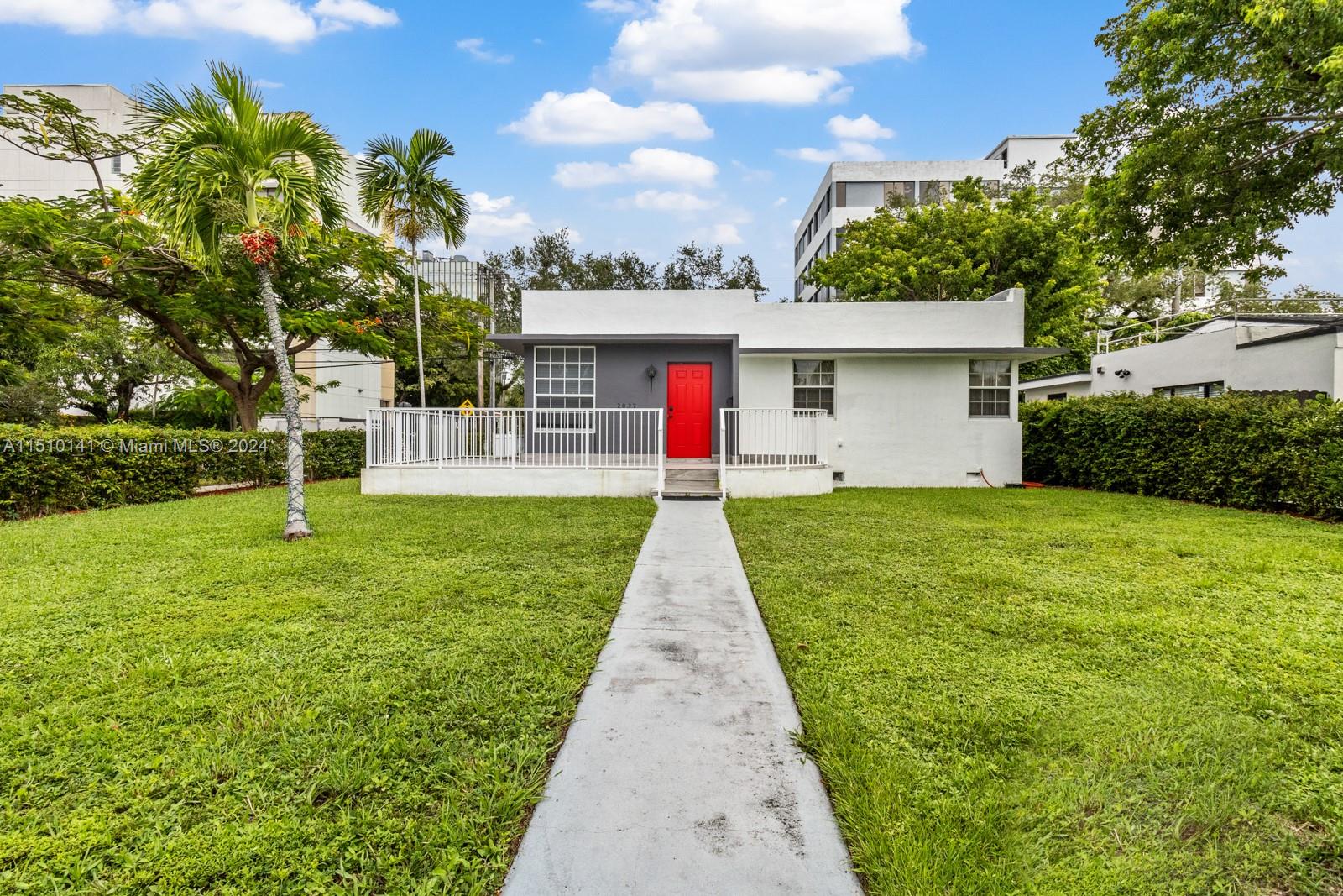 2037 Southwest 22nd Terrace Miami, FL 33145 - Photo 7 of 19 a front view of a house with a yard and garage