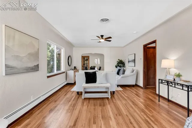 a living room with furniture and a wooden floor