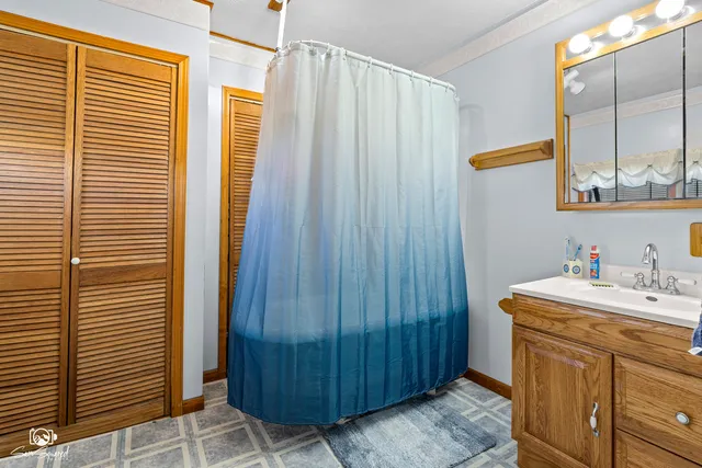 a bathroom with a sink a mirror and shower curtain