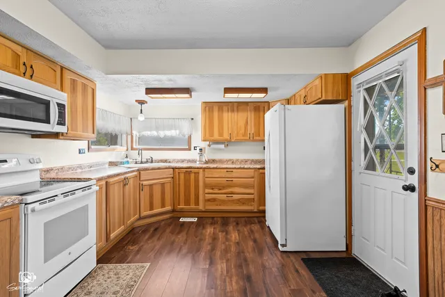 a kitchen with stainless steel appliances a refrigerator sink and microwave