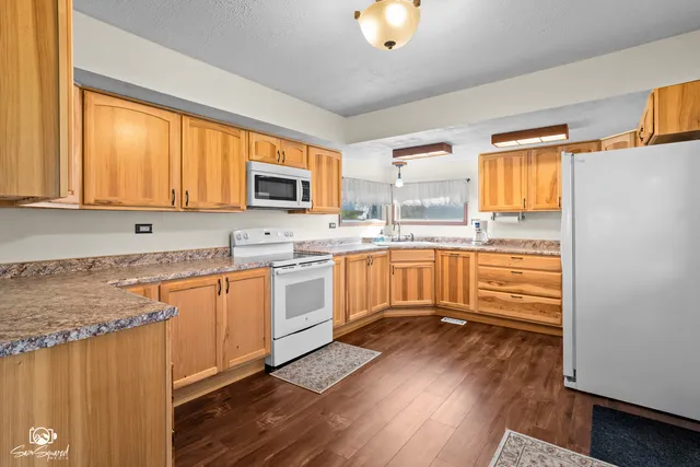 a kitchen with stainless steel appliances granite countertop a stove a sink dishwasher and a refrigerator