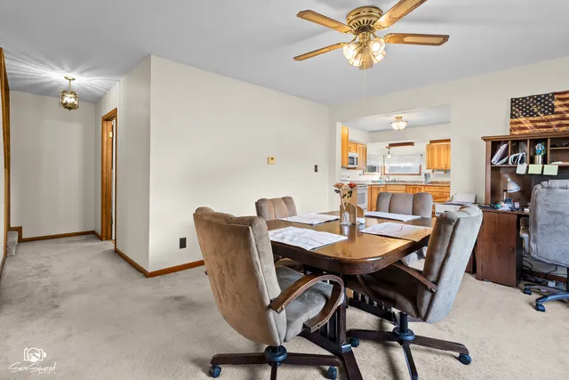 a view of a dining room with furniture and a chandelier fan