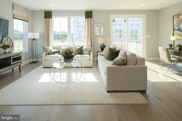 a living room with furniture and large windows