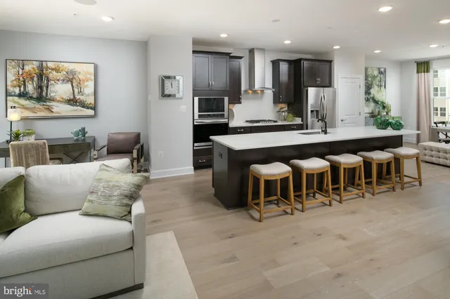 a living room with furniture a large kitchen island a couches and kitchen view