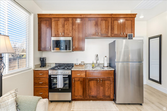 357 East Main Street Enterprise, UT 84725 - Photo 50 of 71 Kitchen featuring stainless steel appliances, wood finish cabinetry, light stone counters, and light wood-type flooring