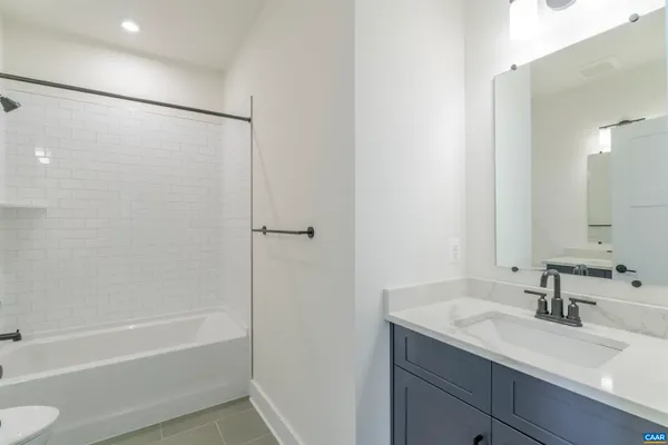 a bathroom with a granite countertop sink toilet and a mirror