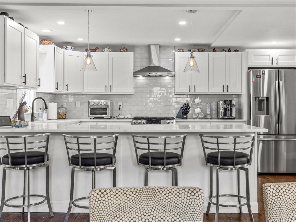 19 Cold Spring Road North Reading, MA 01864 - Photo 4 of 37 a kitchen with stainless steel appliances a table chairs refrigerator and cabinets