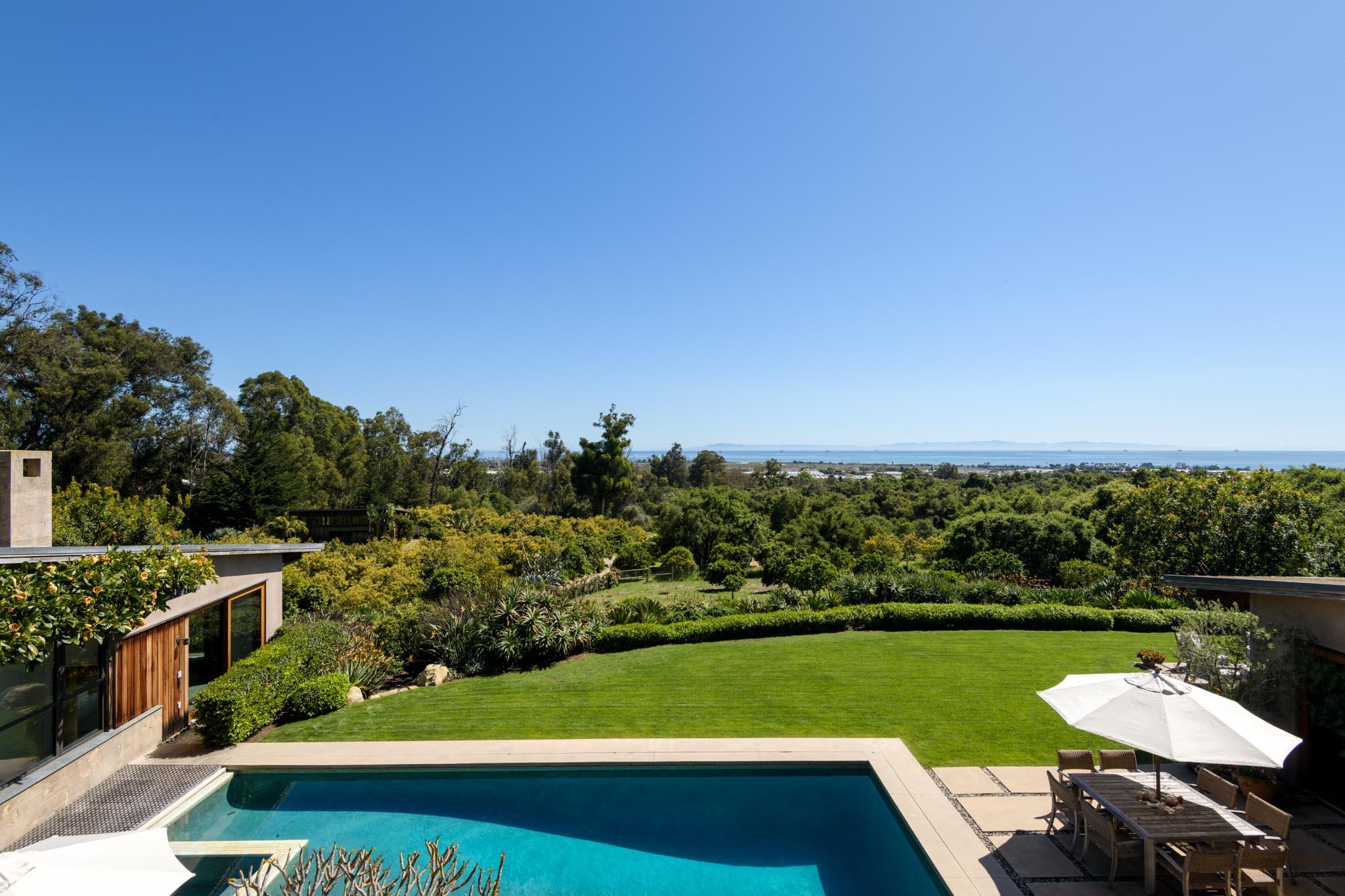 4038 Foothill Road Carpinteria, CA 93013 - Photo 20 of 36 a view of a swimming pool and lounge chairs in back yard of the house