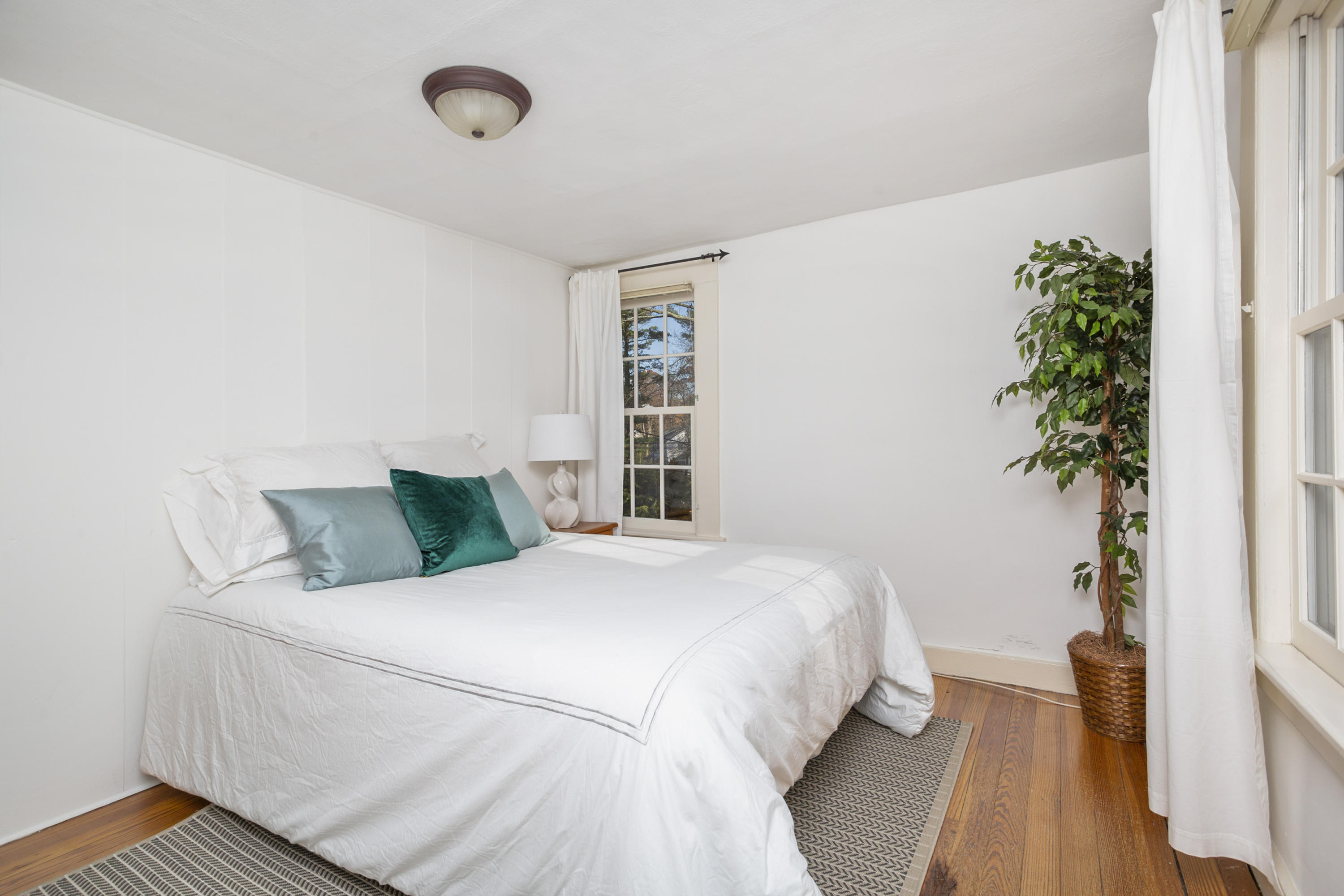 315 Middlesex Road Darien, CT 06820 - Photo 40 of 59 a bedroom with a large bed and a potted plant