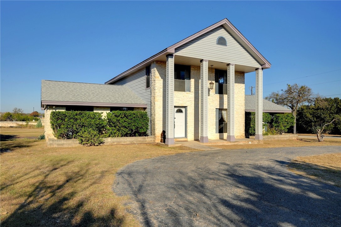 a view of a house with a yard and potted plants