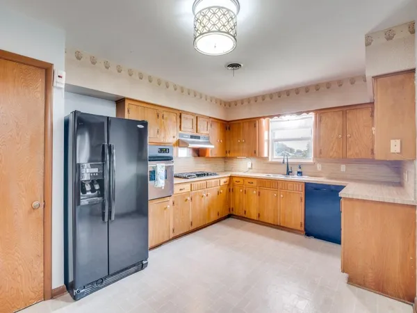 a large kitchen with a large window and stainless steel appliances