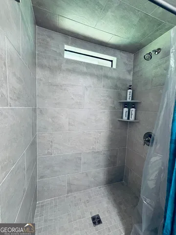 a bedroom with a bed and a flat tv screen on the dresser