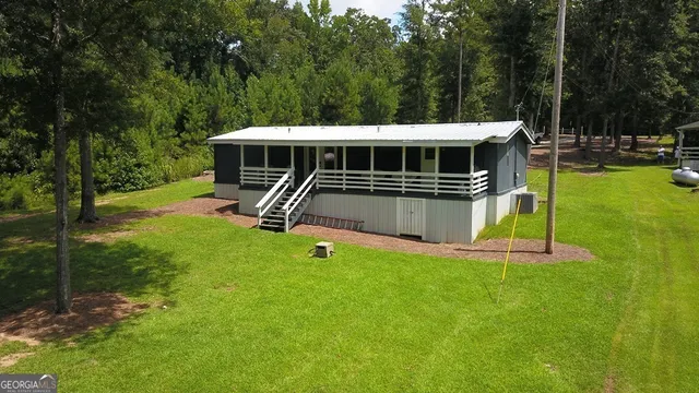 a view of a house with a backyard and a patio