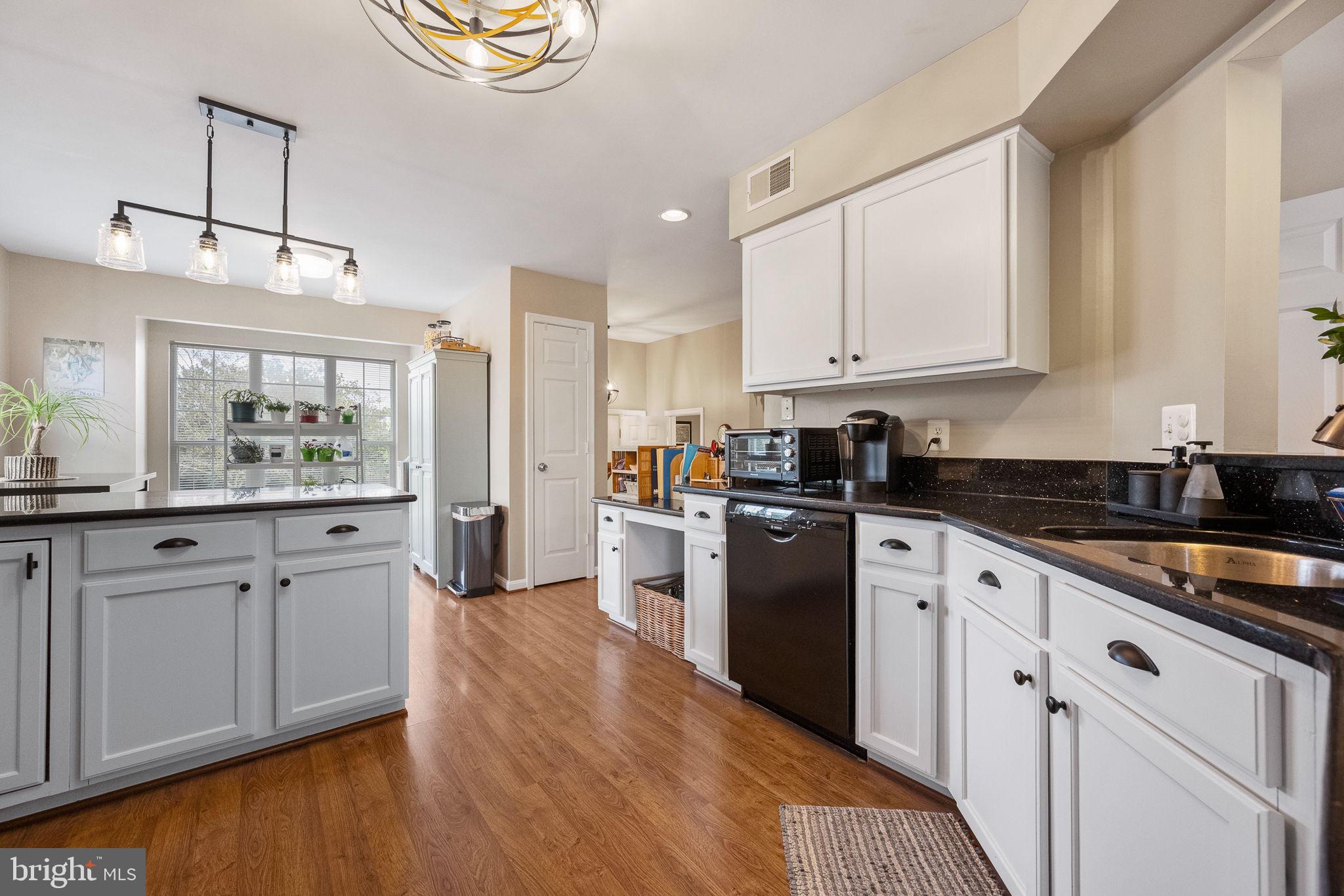 43111 Gatwick Square Ashburn, VA 20147 - Photo 11 of 34 a large kitchen with stainless steel appliances granite countertop a lot of counter space and wooden floors