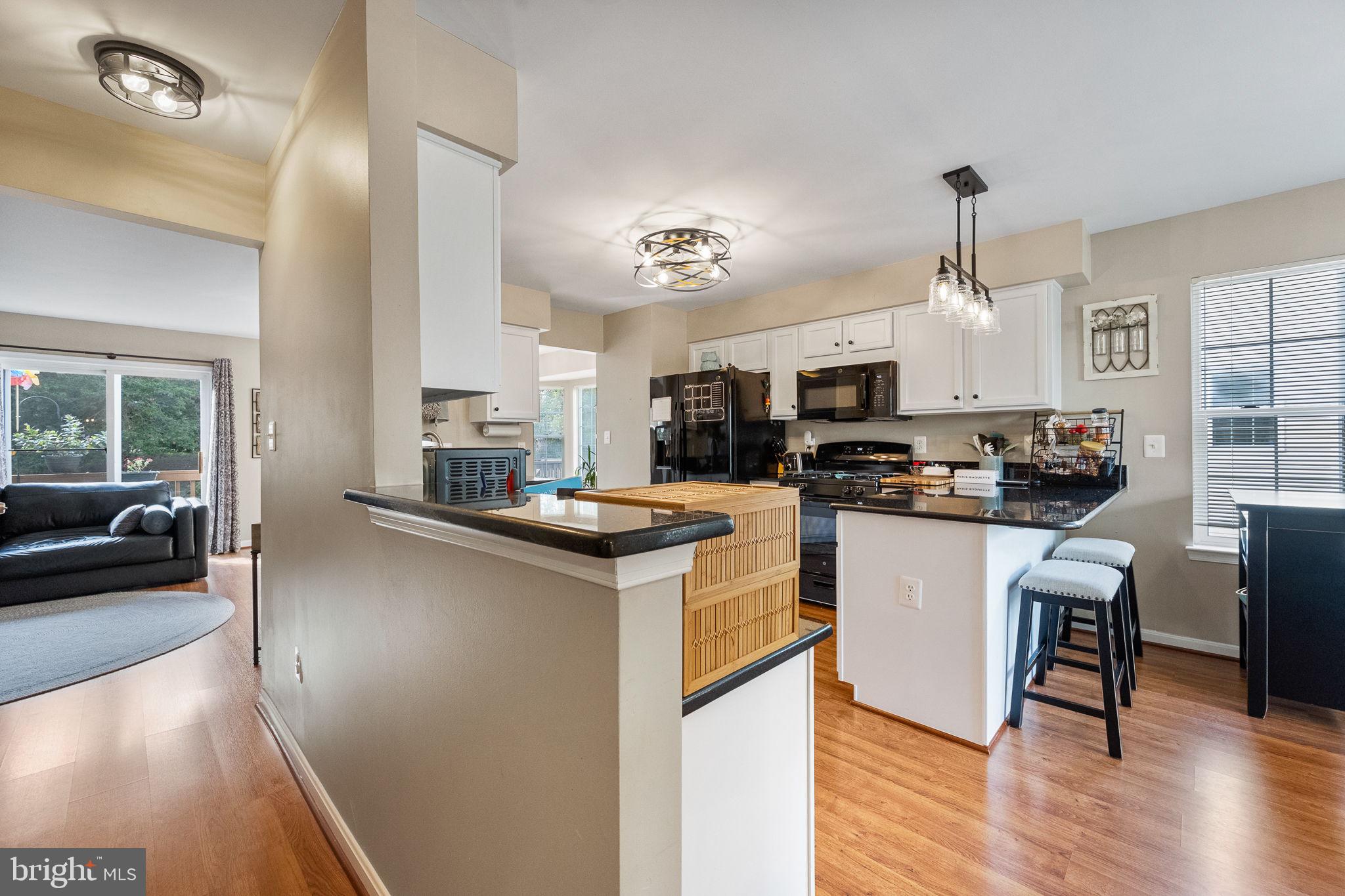 43111 Gatwick Square Ashburn, VA 20147 - Photo 7 of 34 a kitchen with stainless steel appliances kitchen island granite countertop a sink cabinets and wooden floor