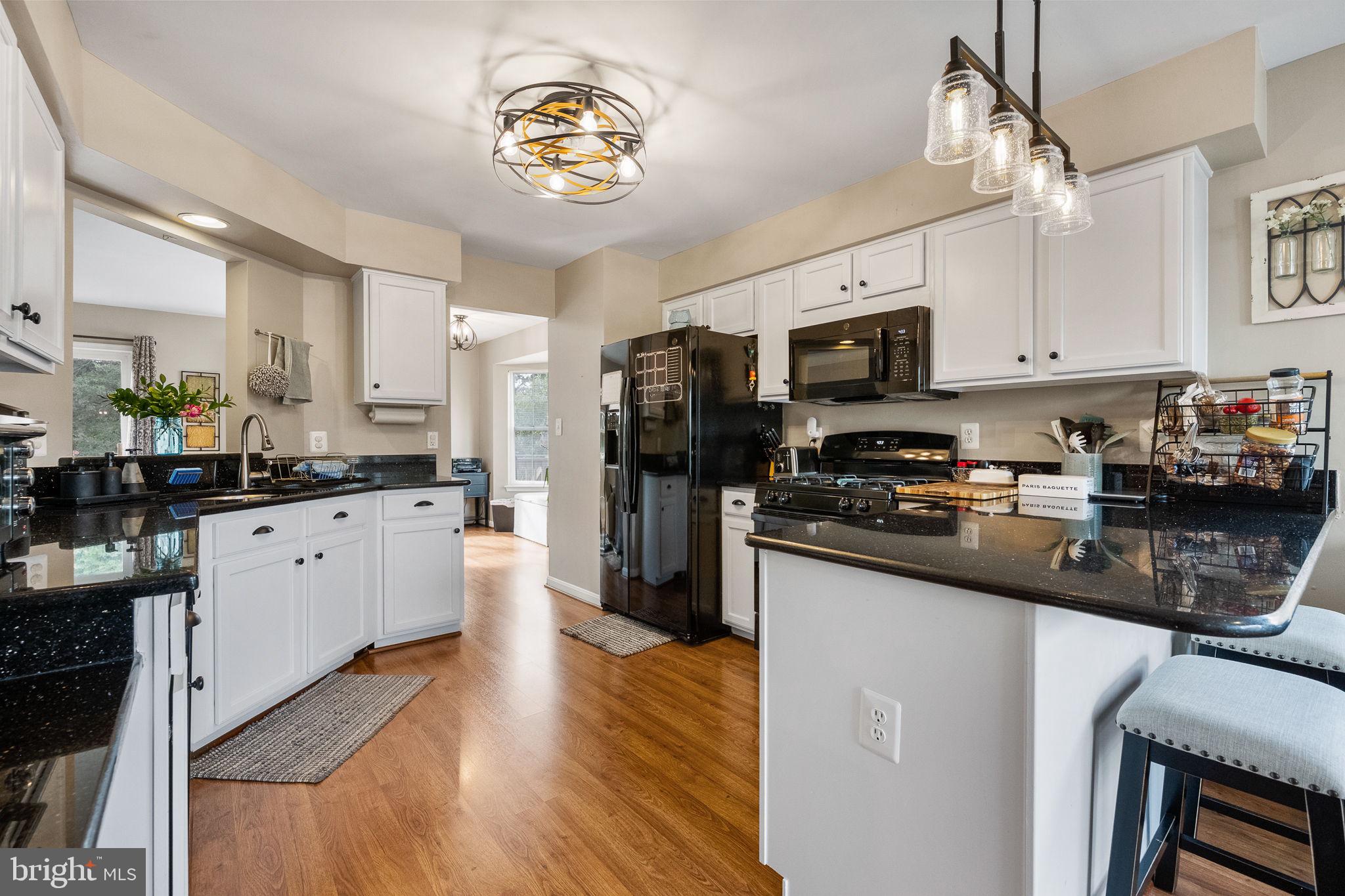 43111 Gatwick Square Ashburn, VA 20147 - Photo 8 of 34 a kitchen with stainless steel appliances a refrigerator a stove top oven a sink dishwasher and white cabinets with wooden floor