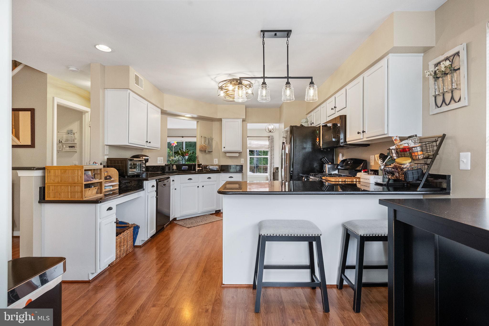 43111 Gatwick Square Ashburn, VA 20147 - Photo 10 of 34 a kitchen with stainless steel appliances a dining table chairs microwave and sink