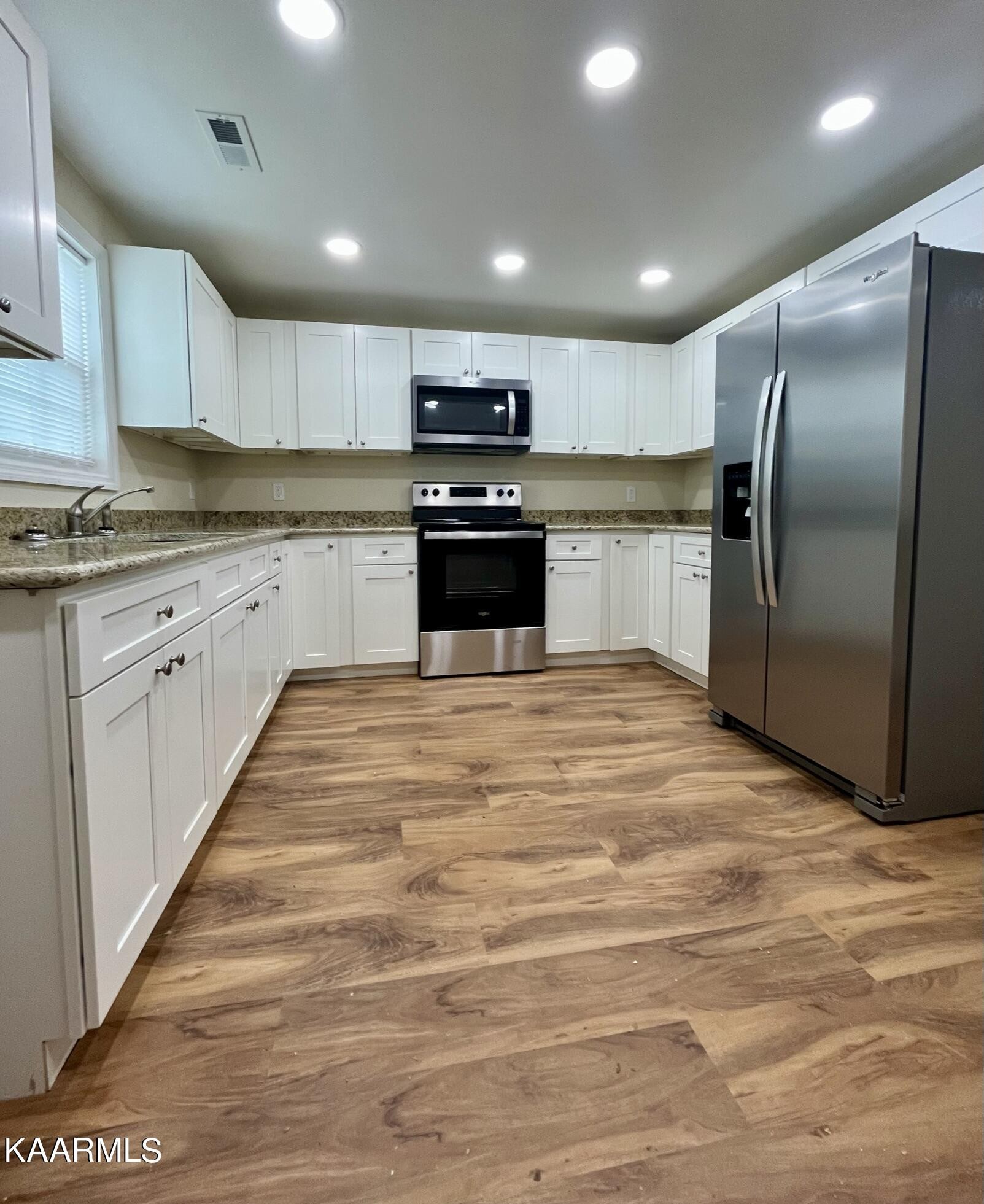 980 Sweetwater Road Philadelphia, TN 37846 - Photo 3 of 20 a kitchen with granite countertop a refrigerator and a stove top oven