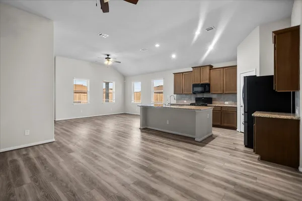 a kitchen with a refrigerator and a stove top oven