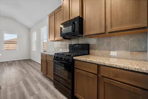 a kitchen with granite countertop a sink and a stove top oven