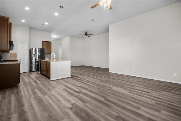 a view of a livingroom with furniture a ceiling fan and wooden floor