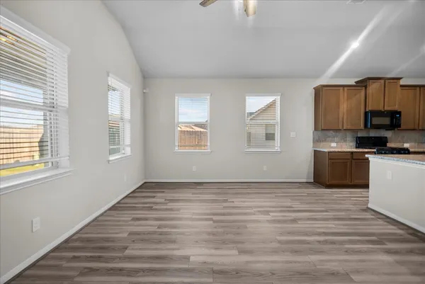 a view of kitchen with granite countertop cabinets and window
