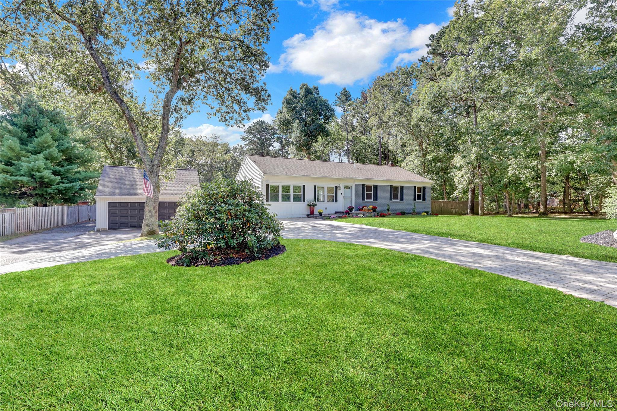 590 Whiskey Road Ridge, NY 11961 - Photo 1 of 1 Ranch-style home featuring concrete driveway, view of wooded area, and a garage