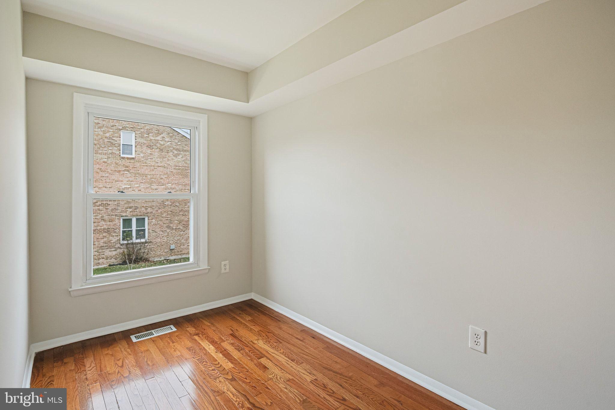 9304 Canterbury Riding, Unit 21 Laurel, MD 20723 - Photo 13 of 29 wooden floor in an empty room with a window