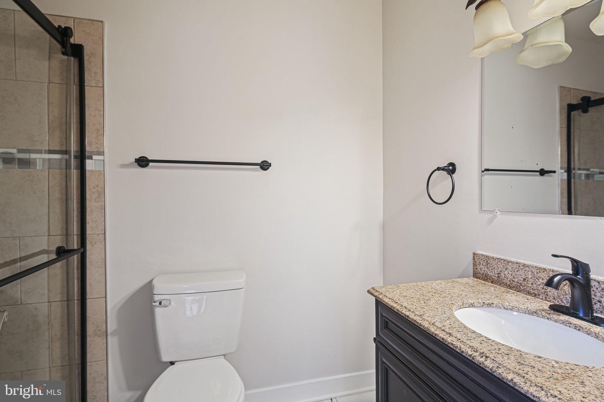 9304 Canterbury Riding, Unit 21 Laurel, MD 20723 - Photo 21 of 29 a bathroom with a granite countertop sink toilet and shower