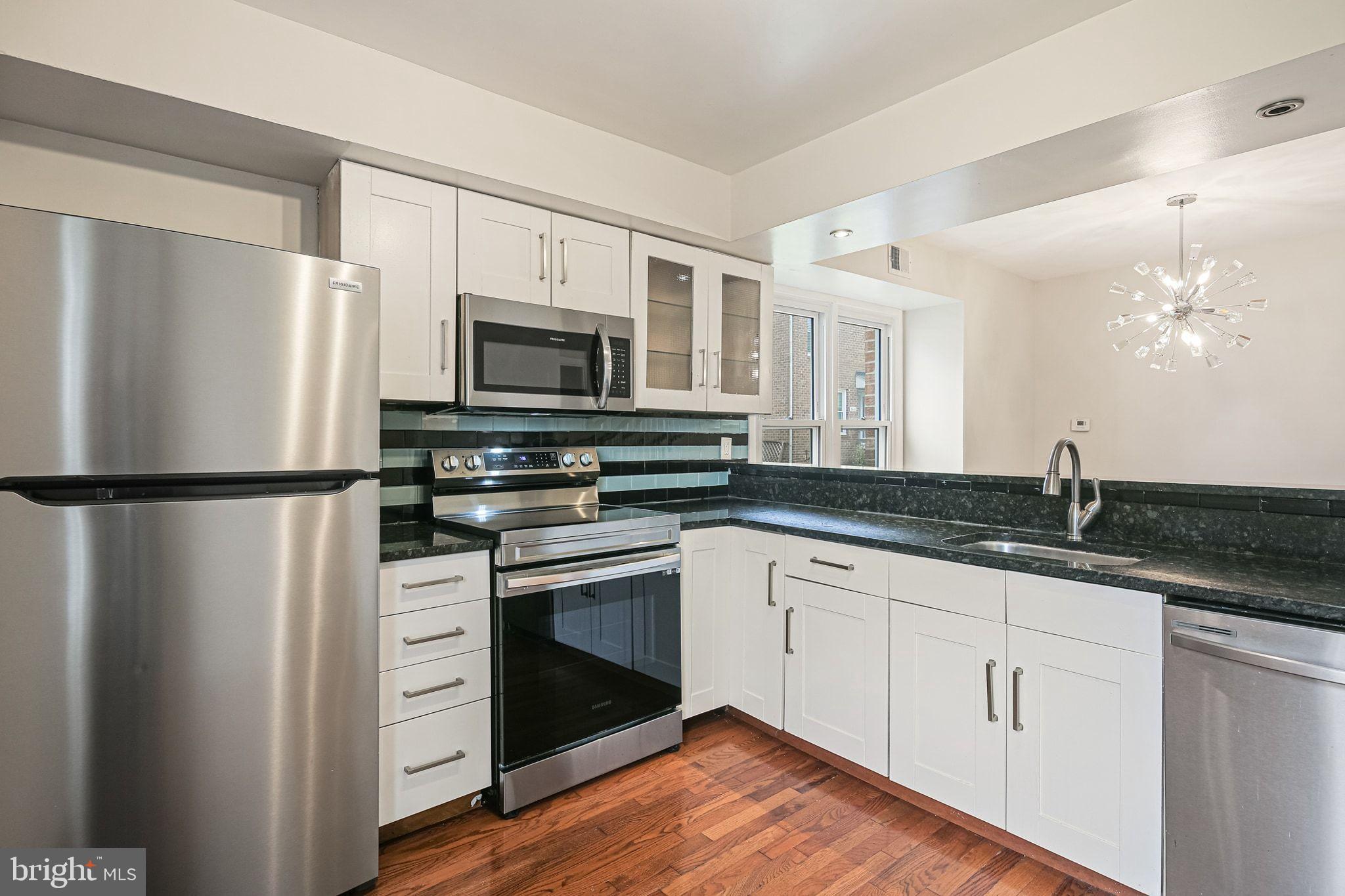 9304 Canterbury Riding, Unit 21 Laurel, MD 20723 - Photo 5 of 29 a kitchen with granite countertop a refrigerator stove and sink