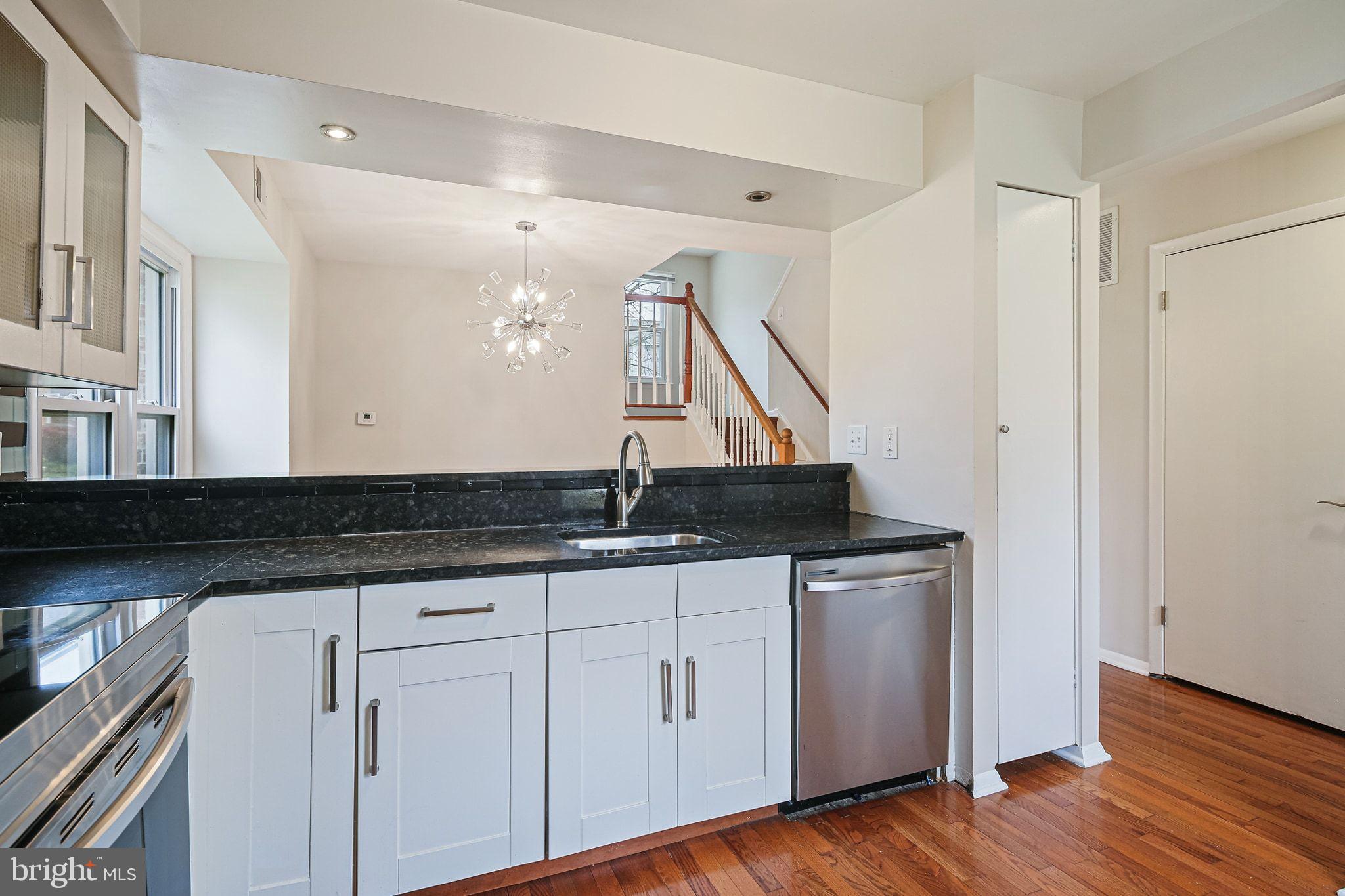 9304 Canterbury Riding, Unit 21 Laurel, MD 20723 - Photo 6 of 29 a kitchen with granite countertop a sink and wooden floor