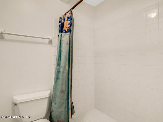 85 Debarry Avenue, Unit 1066 Orange Park, FL 32073 - Photo 23 of 24 a bathroom with a toilet and a shower curtain