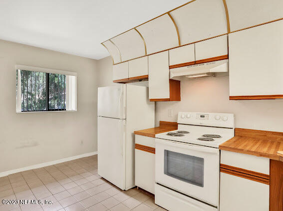 85 Debarry Avenue, Unit 1066 Orange Park, FL 32073 - Photo 6 of 24 a kitchen with stainless steel appliances white cabinets and a refrigerator