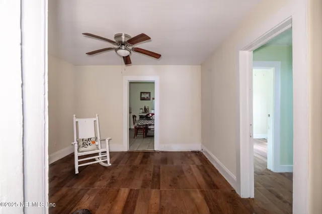 a view of a room with wooden floor and white walls
