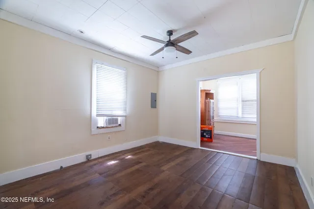 a view of a hallway with wooden floor and a living room