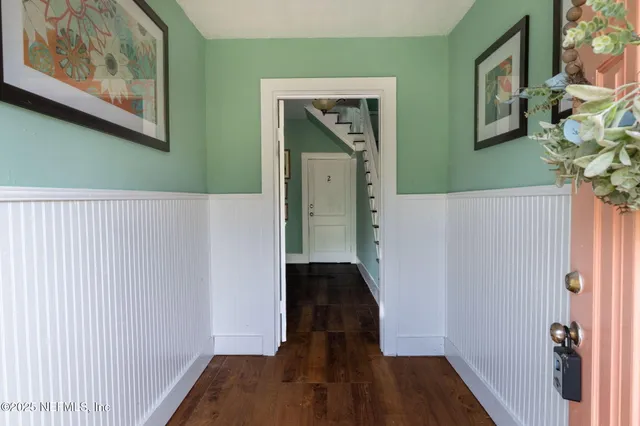 a view of a room with wooden floor a ceiling fan and windows