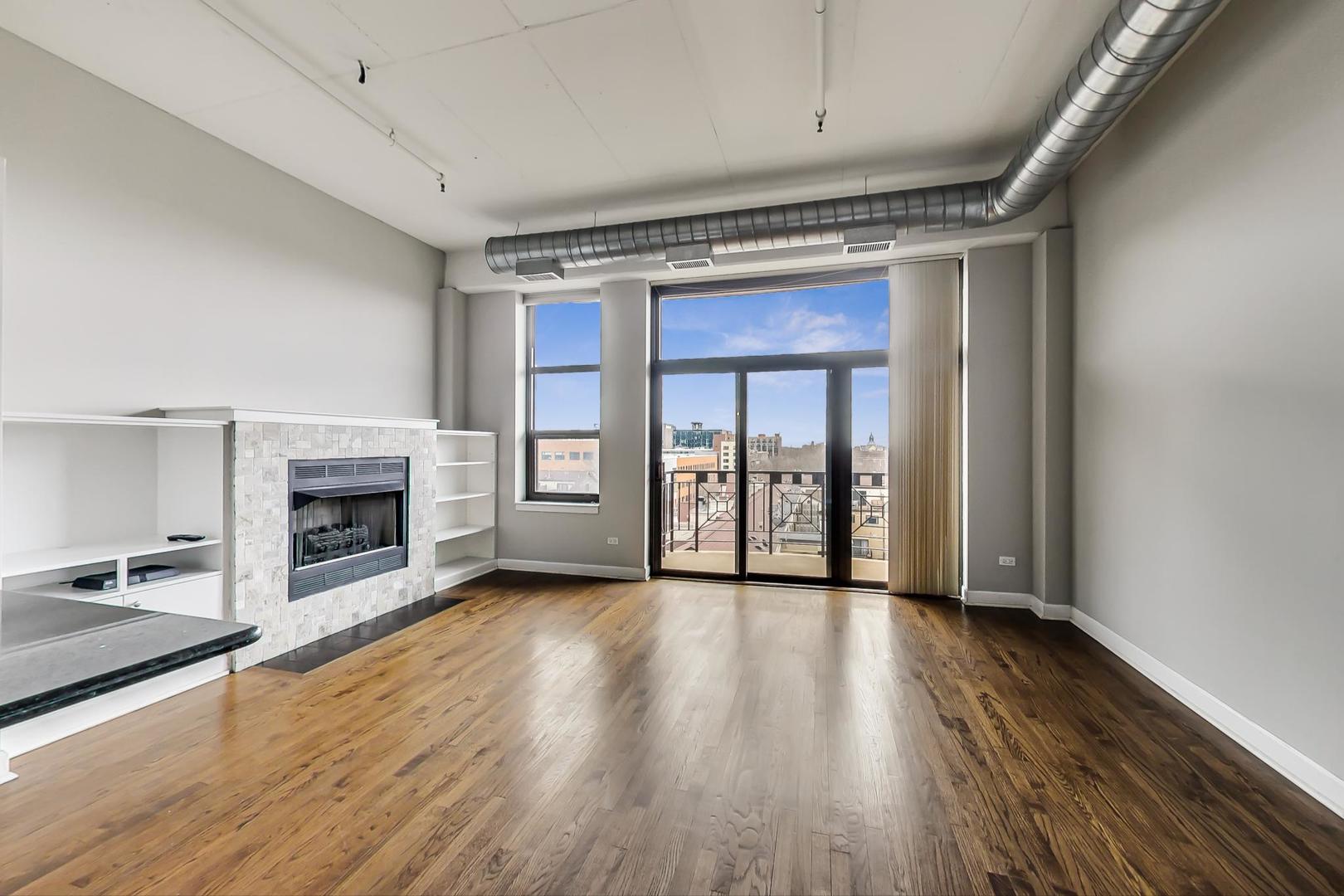 1301 West Madison Street, Unit 511 Chicago, IL 60607 - Photo 11 of 24 a view of an empty room with wooden floor fireplace and a window