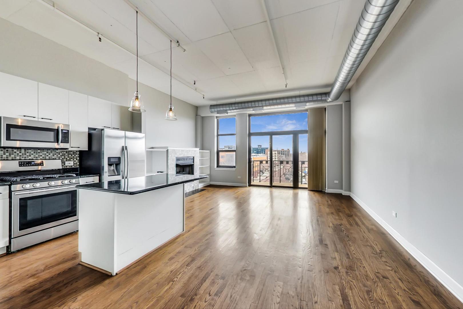 1301 West Madison Street, Unit 511 Chicago, IL 60607 - Photo 4 of 24 a kitchen with stainless steel appliances granite countertop a refrigerator a stove top oven a sink dishwasher and wooden floor