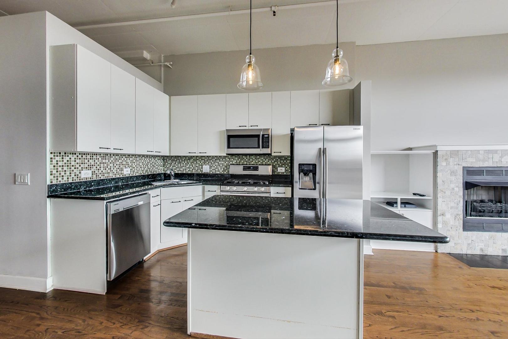 1301 West Madison Street, Unit 511 Chicago, IL 60607 - Photo 7 of 24 a kitchen with stainless steel appliances granite countertop a stove a sink and a refrigerator