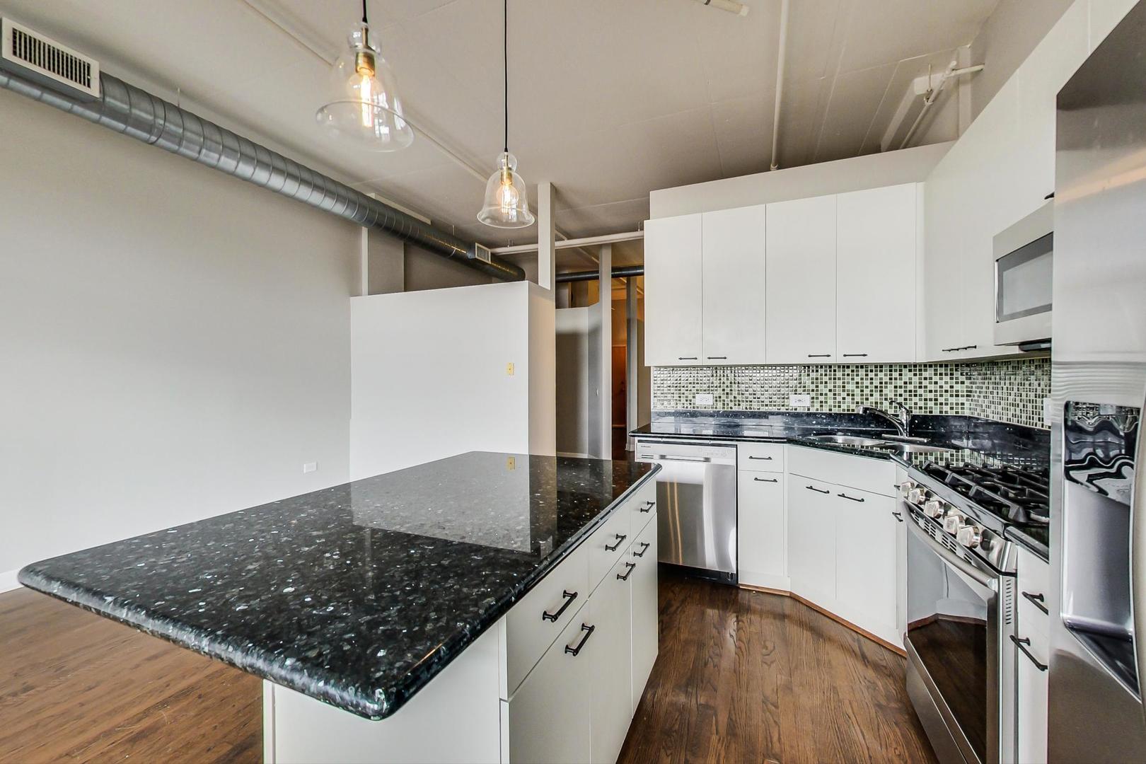 1301 West Madison Street, Unit 511 Chicago, IL 60607 - Photo 9 of 24 a kitchen with stainless steel appliances granite countertop a sink stove and refrigerator