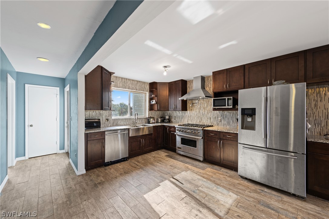 785 Rabbit Road Sanibel, FL 33957 - Photo 5 of 20 a kitchen with a refrigerator sink and wooden floor