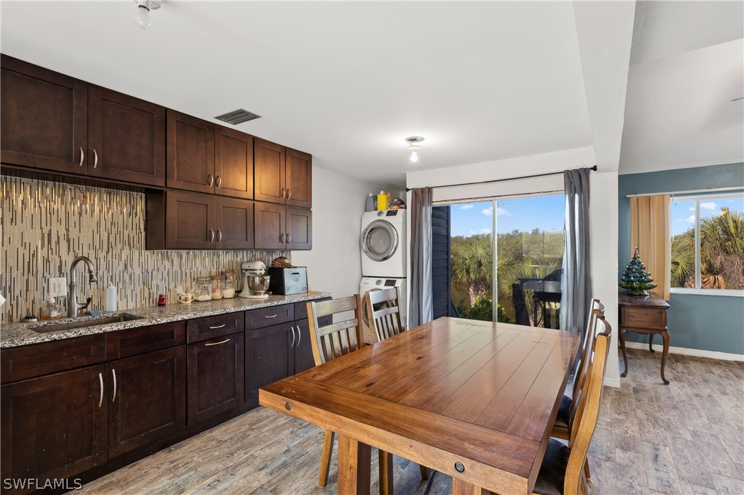 785 Rabbit Road Sanibel, FL 33957 - Photo 6 of 20 a kitchen with stainless steel appliances granite countertop a sink a stove and wooden cabinets
