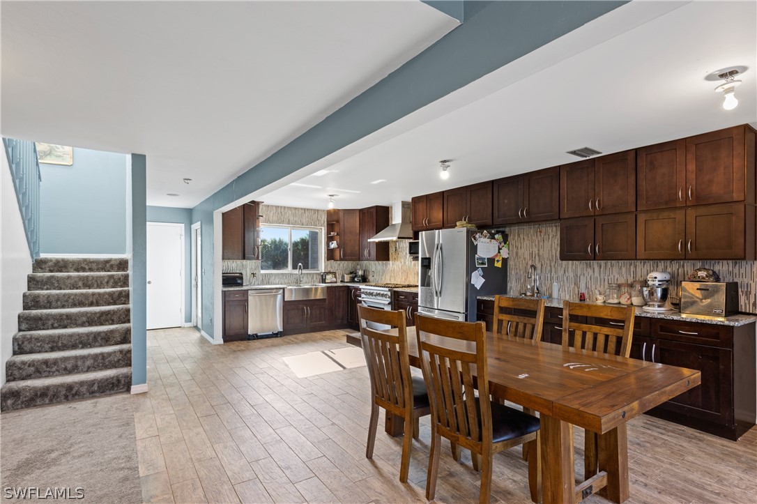 785 Rabbit Road Sanibel, FL 33957 - Photo 7 of 20 a kitchen with stainless steel appliances kitchen island granite countertop a table chairs and a refrigerator