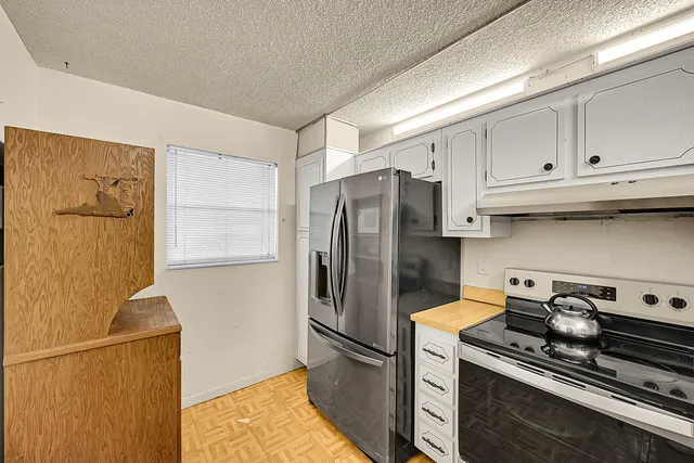 a kitchen with stainless steel appliances granite countertop a refrigerator a stove and a sink with cabinets