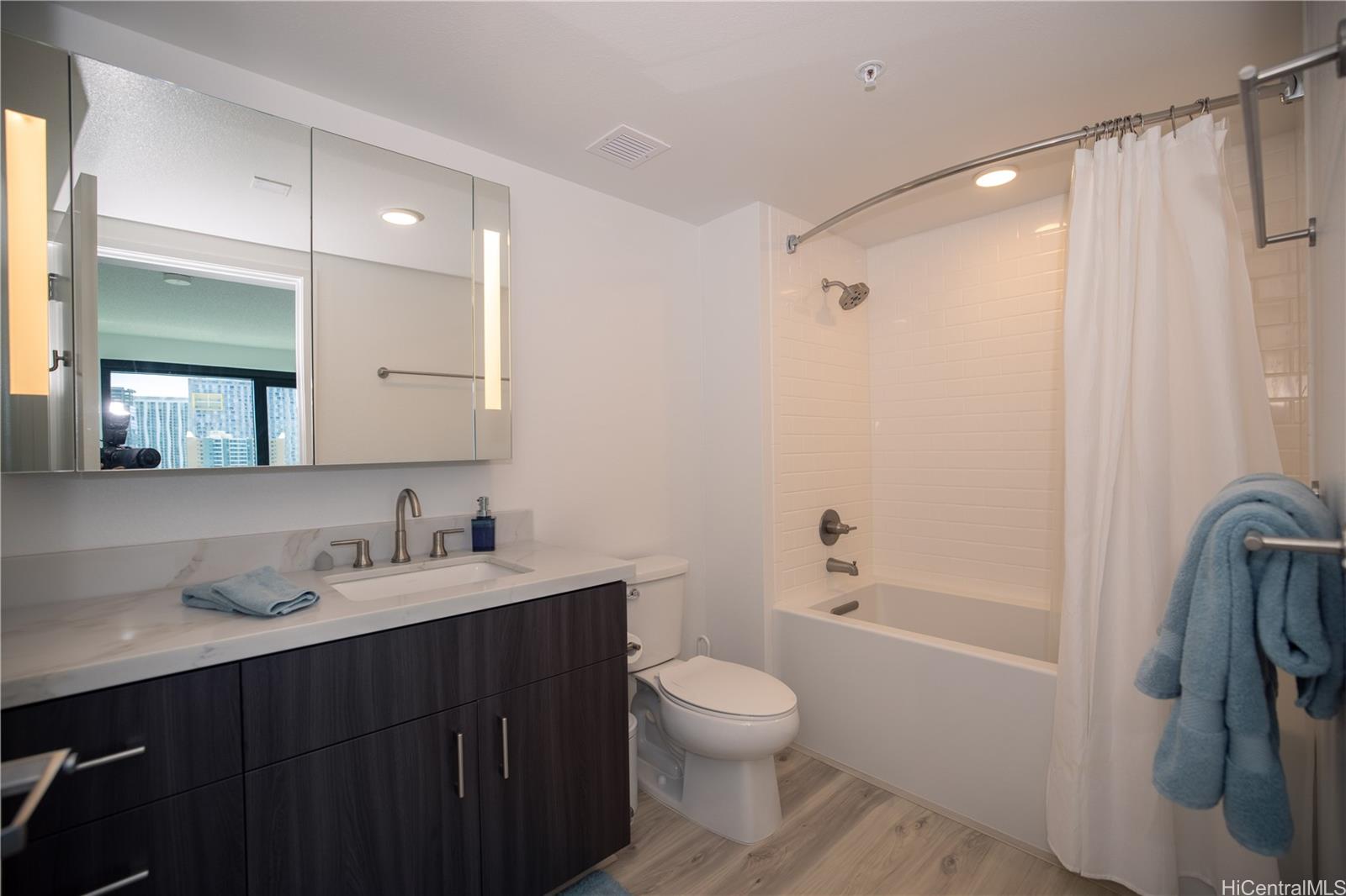 615 Keawe Street, Unit 2408 Honolulu, HI 96813 - Photo 9 of 16 a bathroom with a sink a toilet and shower