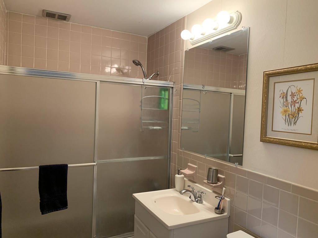 64 Jacqueline Road, Unit 12 Waltham, MA 02452 - Photo 16 of 16 a bathroom with a sink mirror and shower