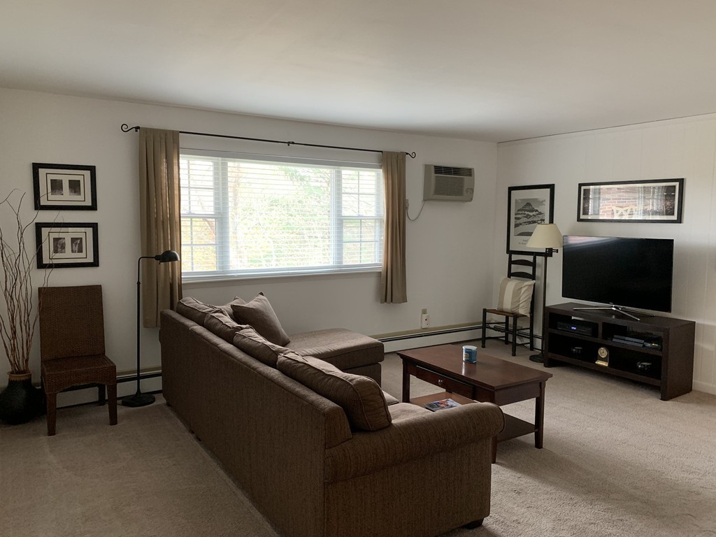 64 Jacqueline Road, Unit 12 Waltham, MA 02452 - Photo 6 of 16 a living room with furniture and a flat screen tv