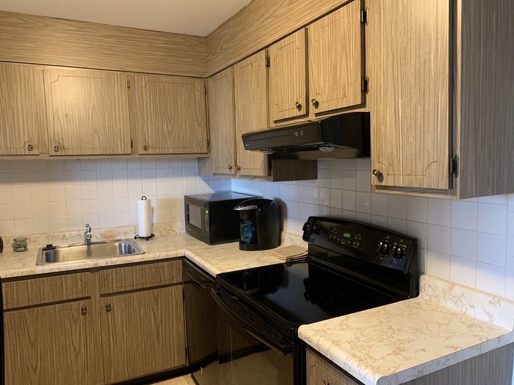 64 Jacqueline Road, Unit 12 Waltham, MA 02452 - Photo 7 of 16 a kitchen with a sink a stove and cabinets